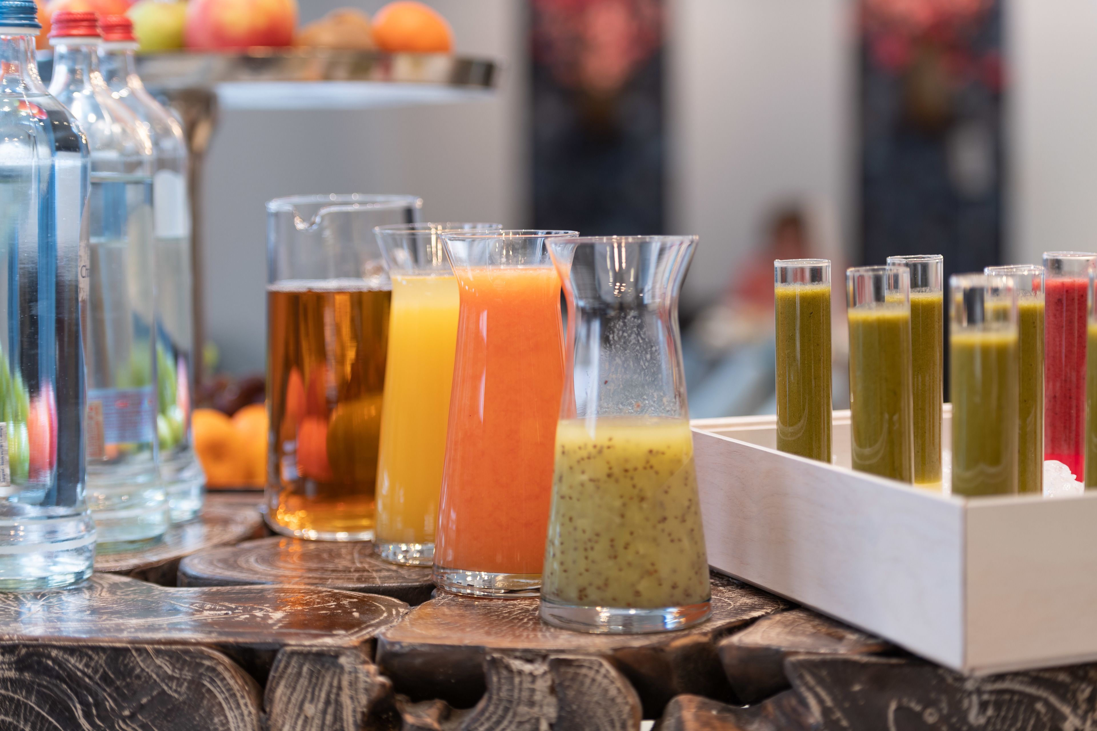 Variedad de bebidas en vasos y botellas sobre una superficie de madera.