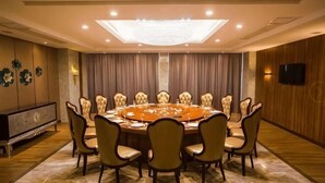 A conference room with a round table, chairs, a television, and a large window. - Hongluyuan Hotel (Shanghai)
