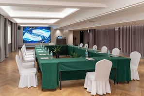 A conference room with a long table, white chairs, and a projection screen. - Hongluyuan Hotel (Shanghai)