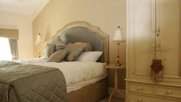Une chambre à coucher avec un grand lit, une armoire et une table de chevet.