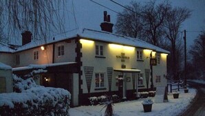 A snow-covered building with a sign reading "The White Horse Inn." - The Winchfield Inn (Hook)