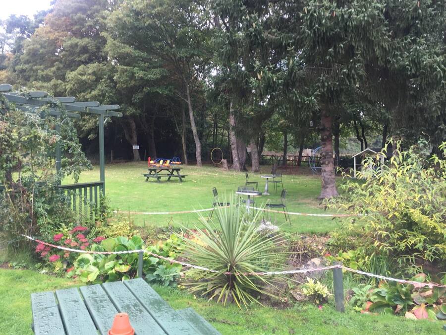 A picnic area with benches, a table, and a playground.