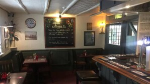 A cozy restaurant interior with a chalkboard menu, wooden tables, and benches. - The Winchfield Inn (Hook)
