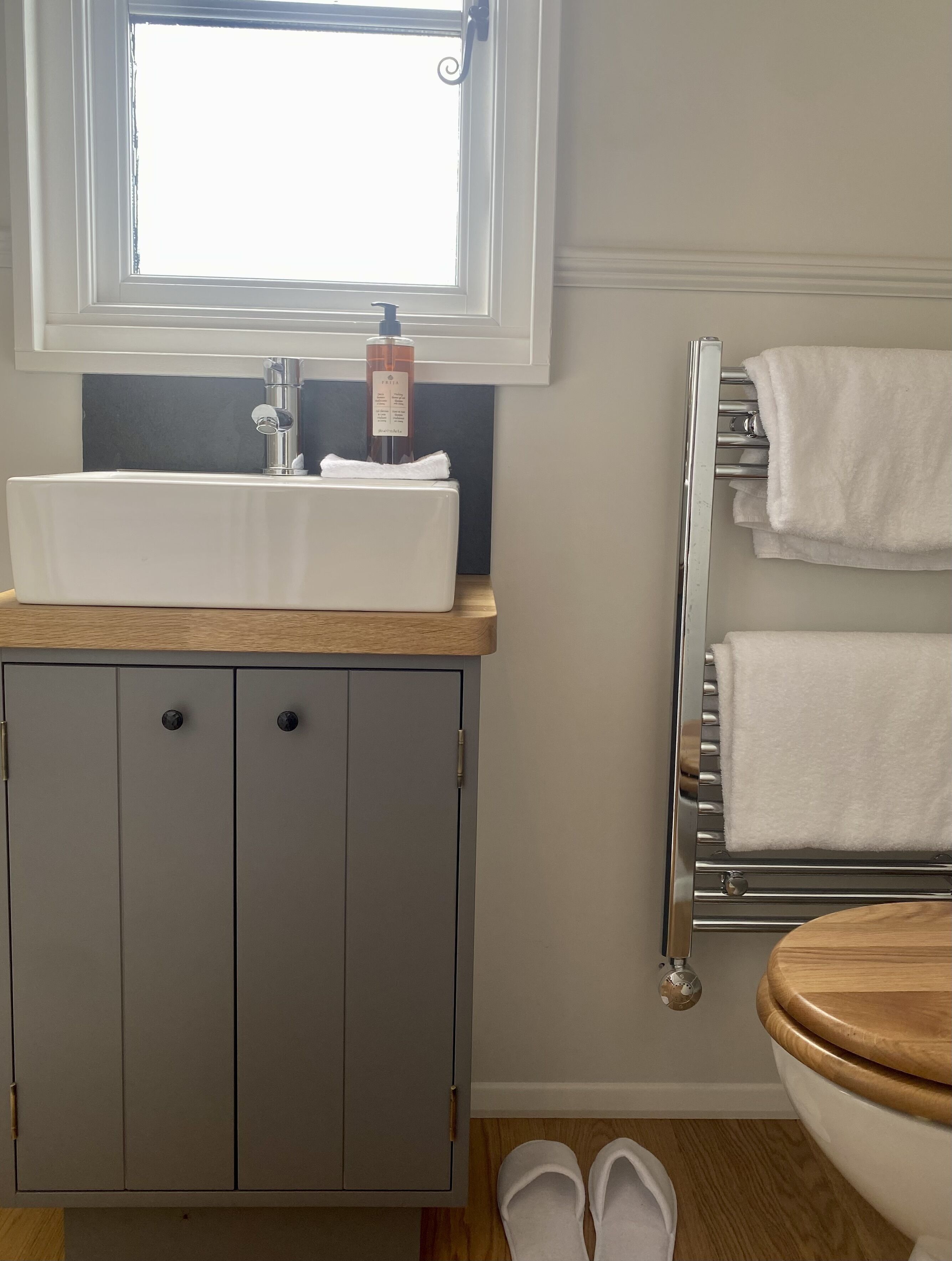 A bathroom with a white sink, a towel rack, and a toilet.