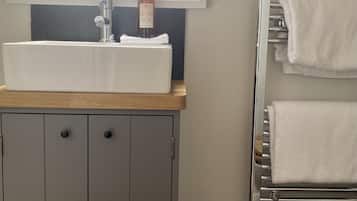 A bathroom with a white sink, a towel rack, and a toilet.