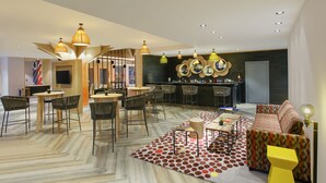 Un interno moderno con un'area bar, posti a sedere e una televisione.