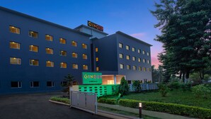 Un hotel dal design moderno, con diversi piani e un evidente cartello 'GINGER'.