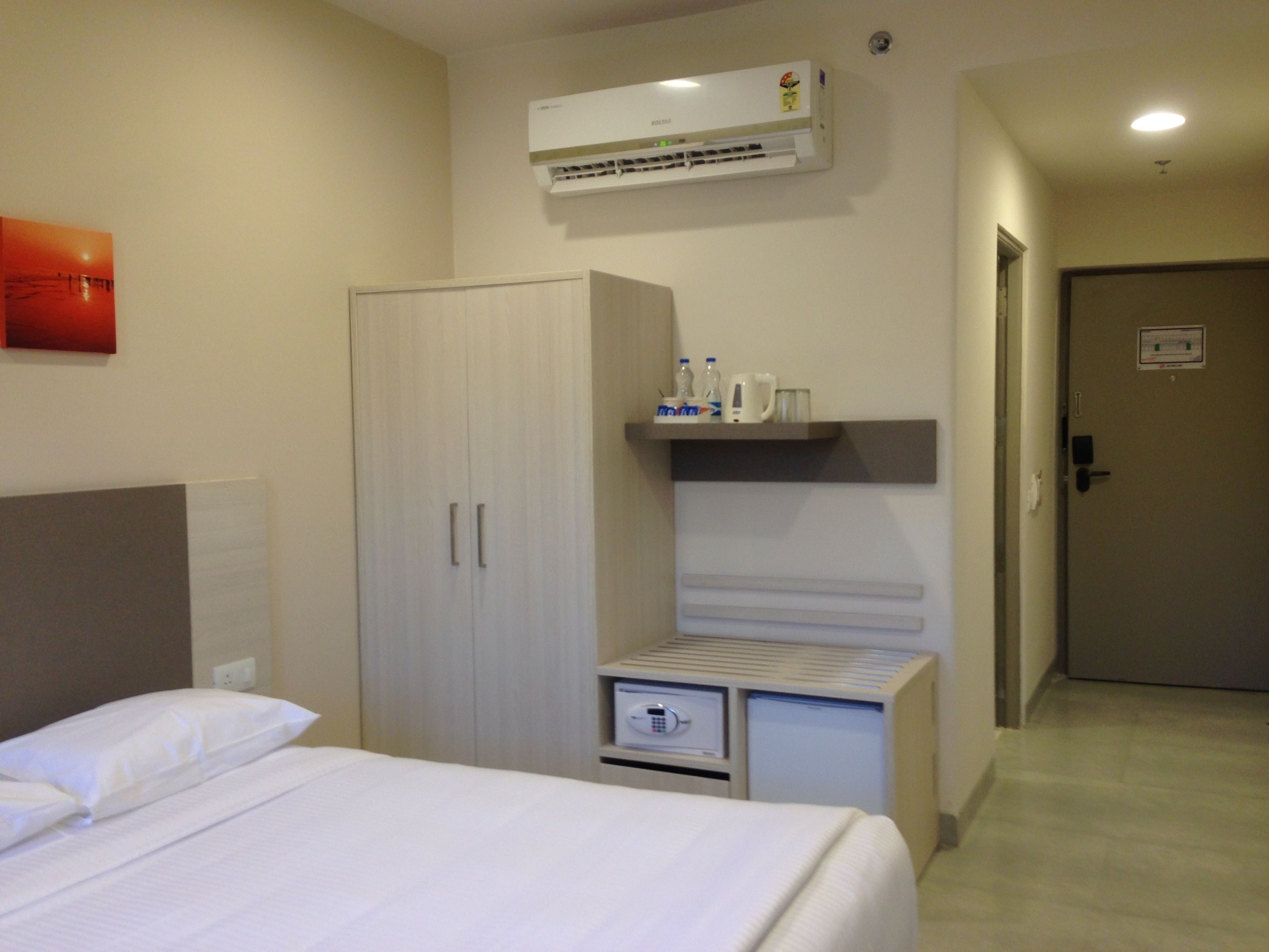 Une chambre d’hôtel équipée d’un lit, d’une armoire, d’un mini-bar et de la climatisation.