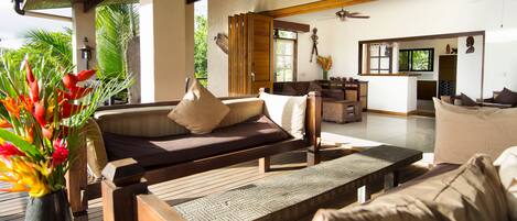 Un salón amplio con un banco de madera, asientos acolchados y una mesa de comedor.
