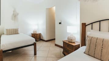 Una habitación de hotel con dos camas, mesitas de noche de madera y lámparas de noche.