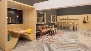 Una sala de estar moderna con sofá, mesa de centro y comedor con sillas.