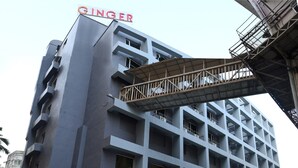 Un edificio moderno con un llamativo letrero 'GINGER', varios pisos y un corredor cubierto.