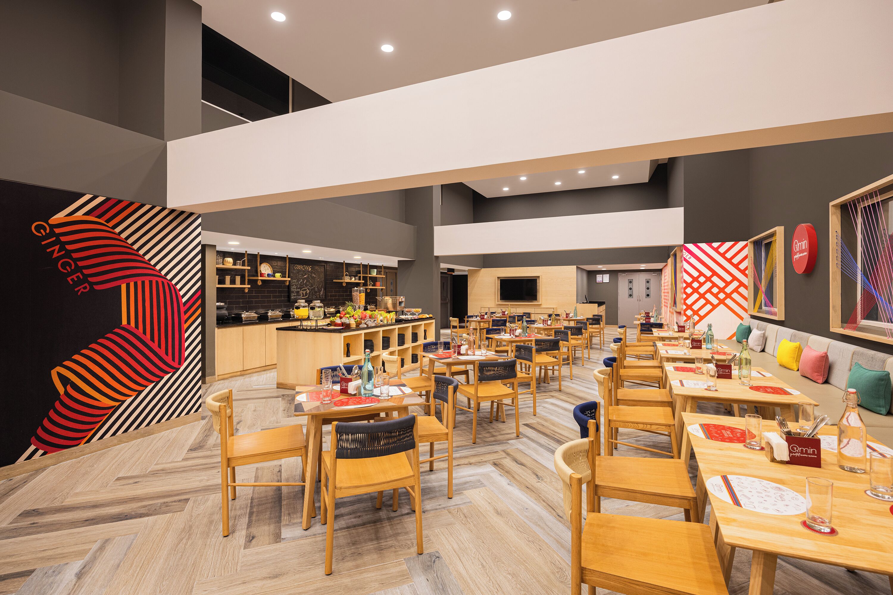 A modern restaurant with wooden tables and chairs, a kitchen area, and a bar.