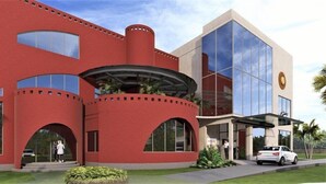 A modern building with a red facade, large windows, and a curved entrance. - Ginger Durgapur (Durgapur)