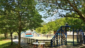 A playground with a climbing structure, a small table, and a fenced area. - VVF Sud Aveyron, Brusque (Brusque)