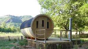 A wooden barrel-shaped structure with a wooden deck and a metal fence. - VVF Sud Aveyron, Brusque (Brusque)