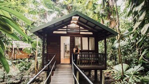 A wooden structure with a balcony, surrounded by dense tropical foliage. - Daintree Wilderness Lodge (Diwan)