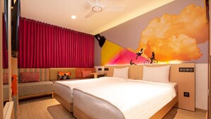 A hotel room with a bed, a sofa, a TV, and a wall mural. - Ginger Mangalore (Mangaluru)