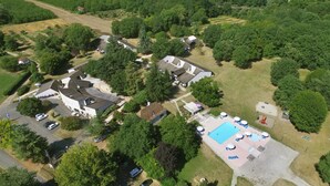 An aerial view of a residential area with houses, a swimming pool, and a parking lot. - VVF Dordogne Lot, Martel-Gluges (Montvalent)