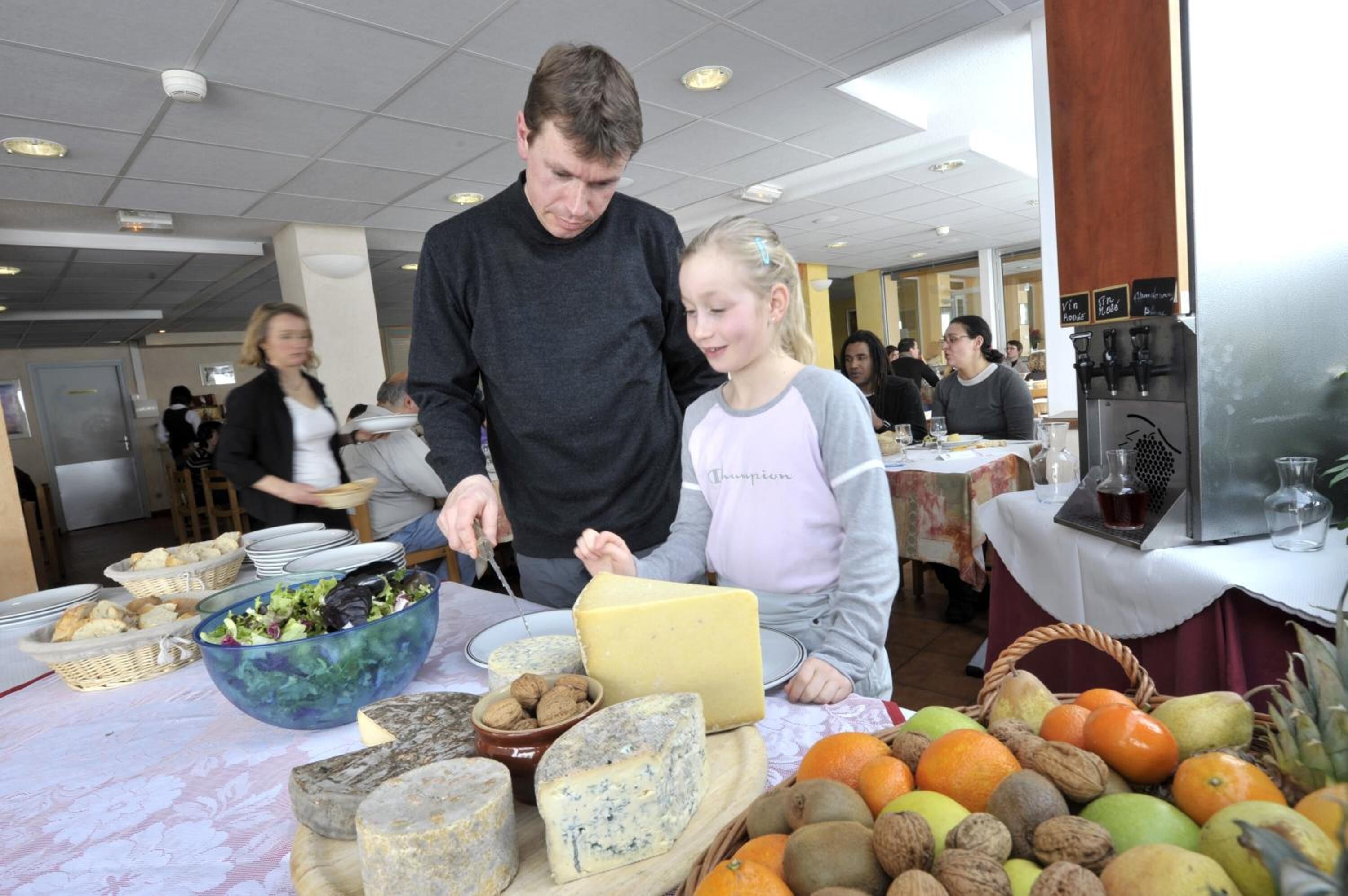 A buffet table with various cheeses, fruits, and nuts.