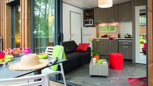 Un intérieur moderne comprenant un canapé, une table à manger et un coin cuisine.