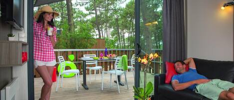 Una sala de estar moderna con un ventanal de vidrio que da a una terraza al aire libre.