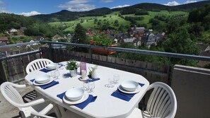 Una mesa para cuatro con vistas panorámicas a un pueblo y colinas al fondo.