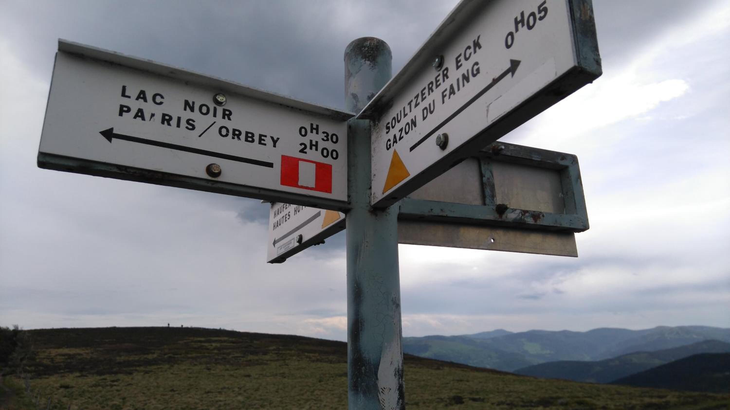 A directional signpost with multiple arrows pointing towards various destinations.