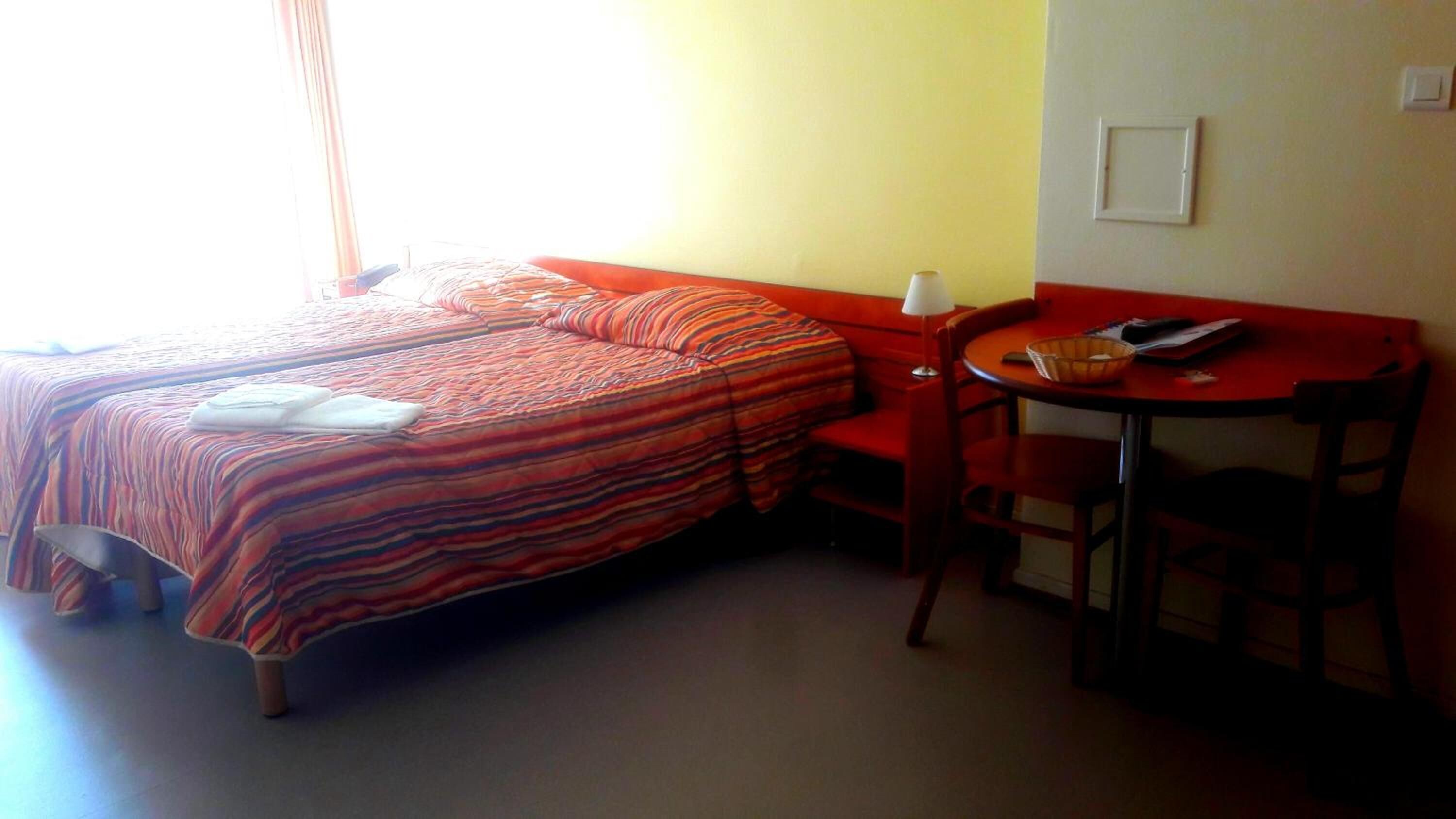 Ein Hotelzimmer mit Bett, Schreibtisch und Stuhl.