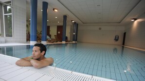 A swimming pool with blue tiles, white walls, and blue pillars. - VVF Alsace Orbey Colmar (Orbey)