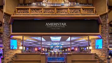 A spacious lobby with a prominent AMERISTAR sign, a bar area, and a view of the ceiling structure.