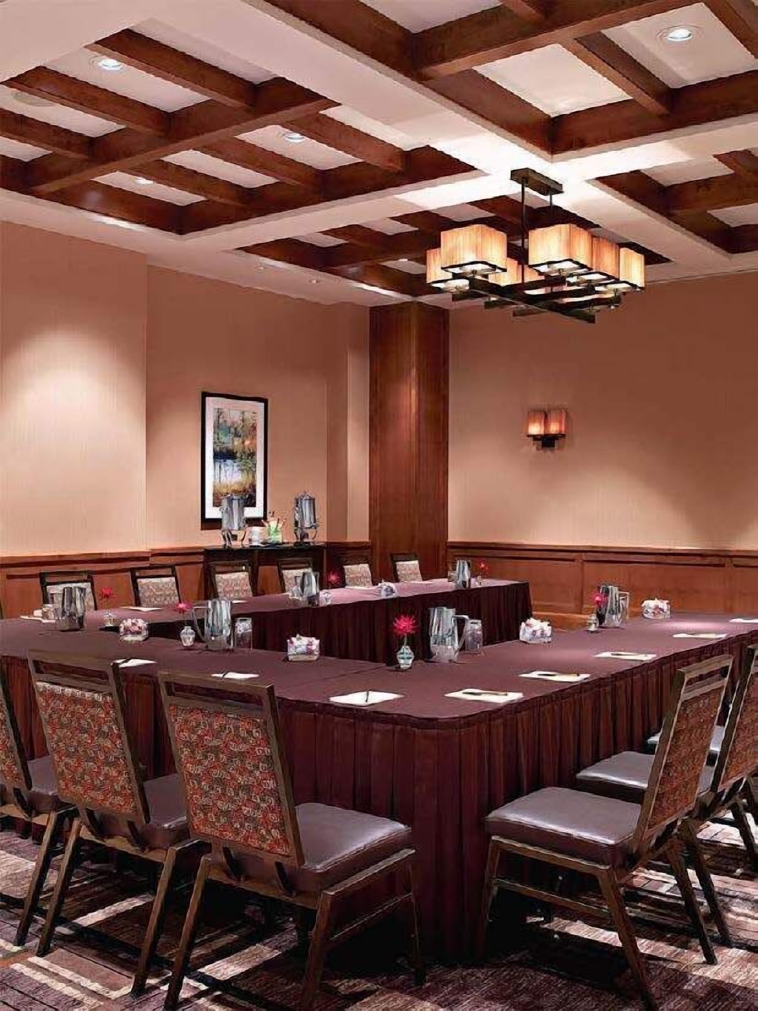 A conference room with a long table, chairs, and a chandelier.