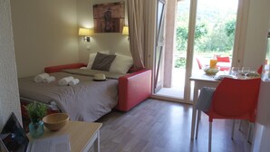 Habitación de hotel con cama, escritorio, silla, mesa, ventana y vistas al exterior.