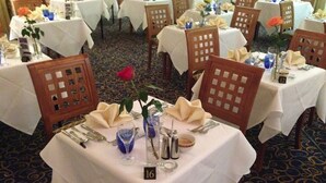 A dining area with tables set for four, each with a white tablecloth, chairs, and table number 16. - Hardwicke Hall Manor Hotel (Hartlepool)
