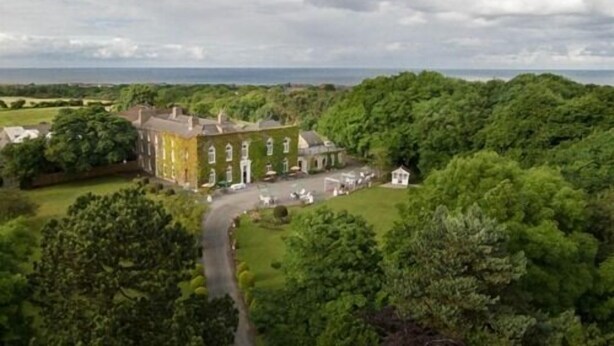 A large, historic building with a symmetrical facade, surrounded by lush greenery and a clear view of the sea. - Hardwicke Hall Manor Hotel (Hartlepool)