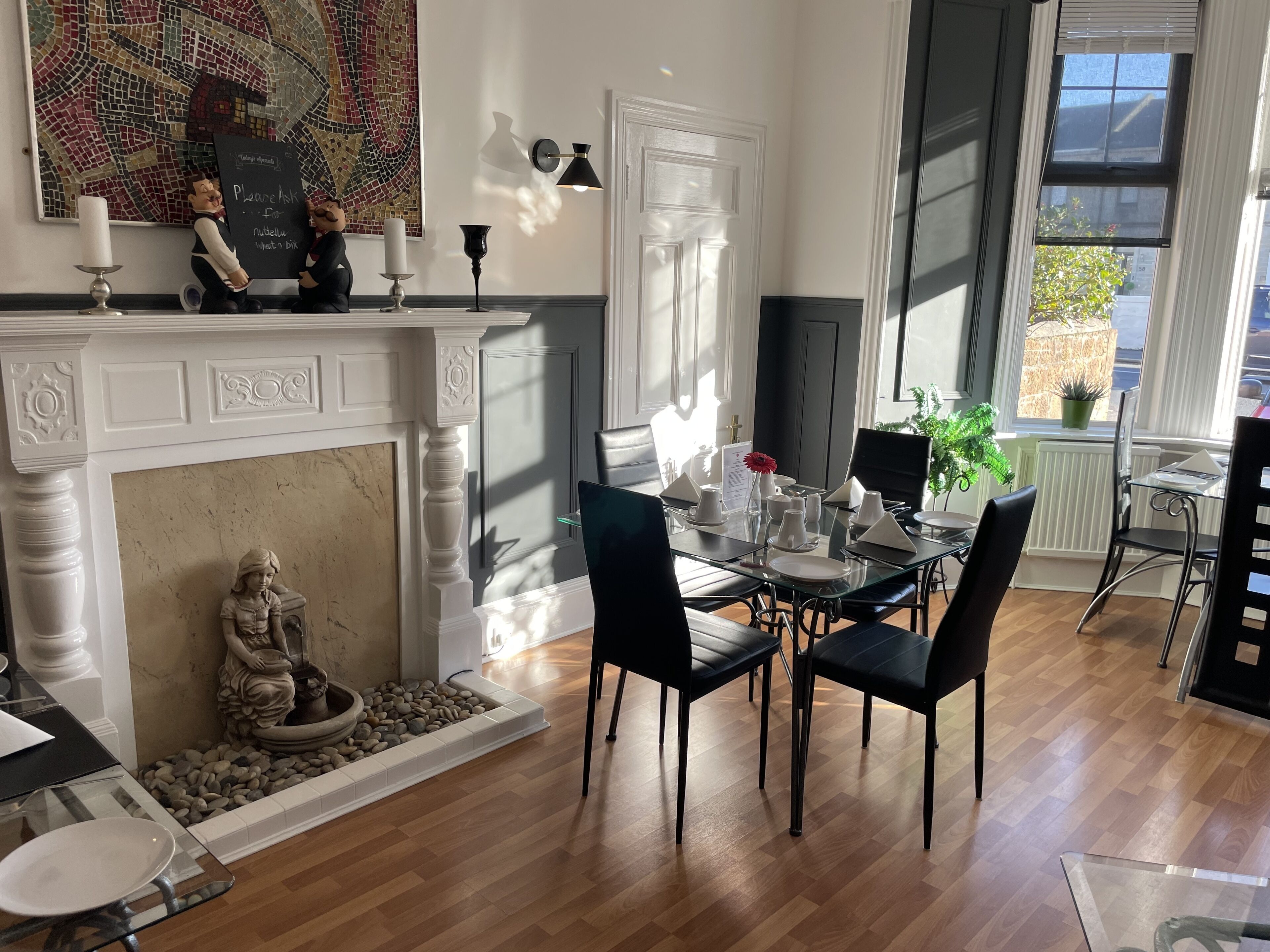 A dining area with a fireplace, a mosaic wall, and a view of the outside.