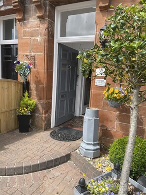 Traditional entrance with a welcoming door, flanked by a fence and gate.