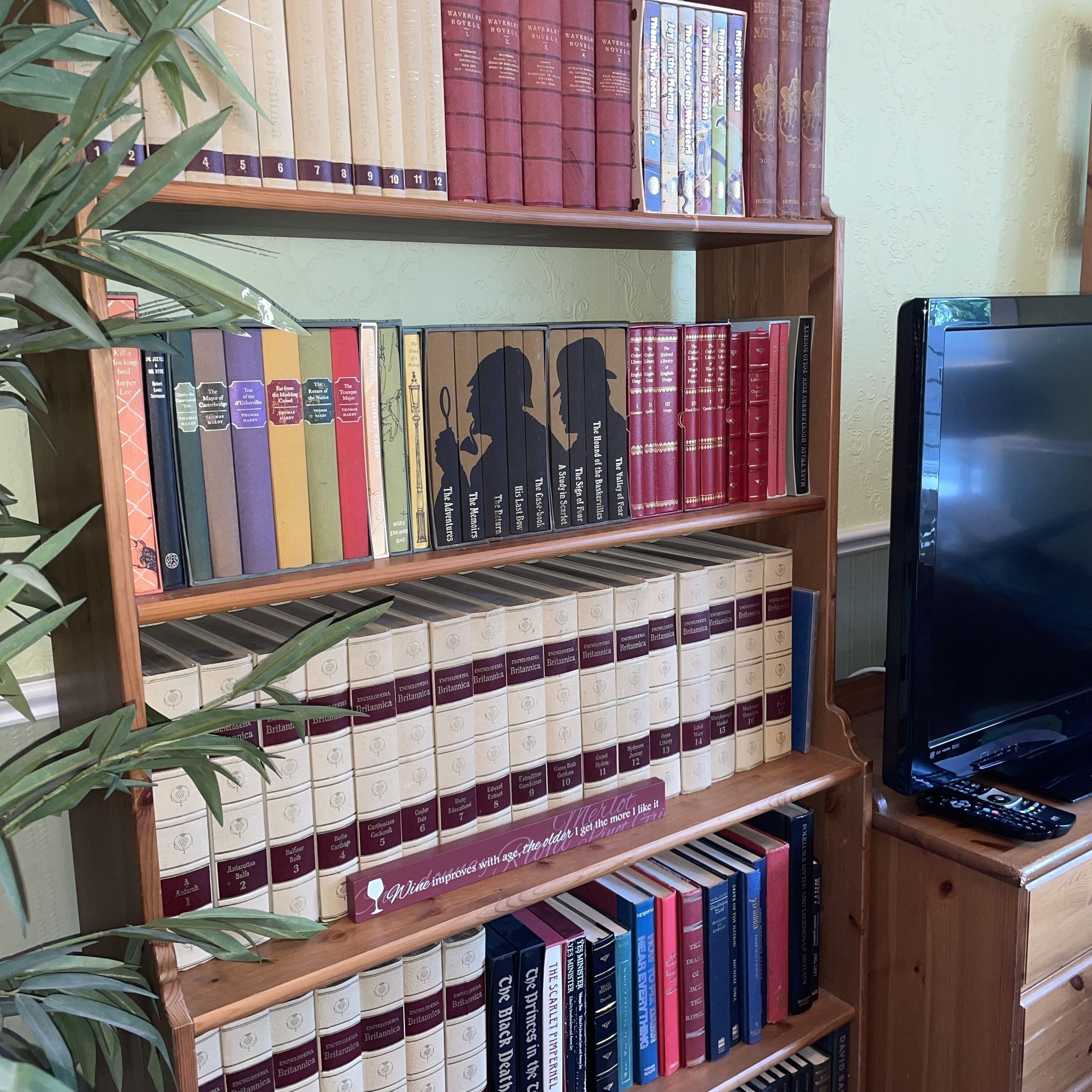 A bookshelf with a variety of books, including boxed sets and standalone volumes.
