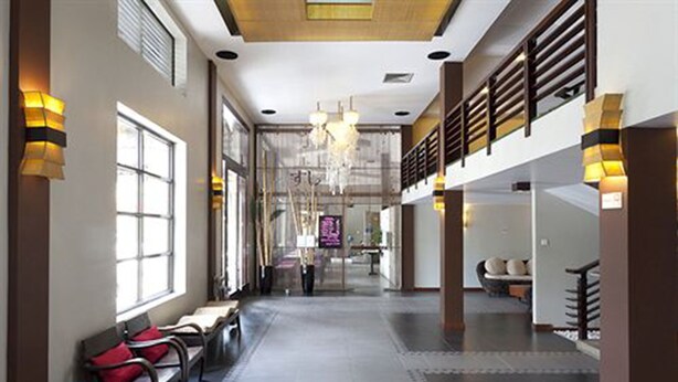 A spacious lobby with high ceilings, a chandelier, and seating areas.