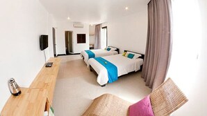 A hotel room with two beds, a wooden desk, a chair, and a TV.