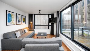 A modern living room with a grey sectional sofa, a black coffee table, and framed artwork on the wall. - Staycity Aparthotels, Liverpool, City Centre (Liverpool)