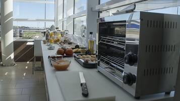 Une cuisine dotée d’une grande fenêtre, d’un four en acier inoxydable et de divers aliments disposés sur le plan de travail.