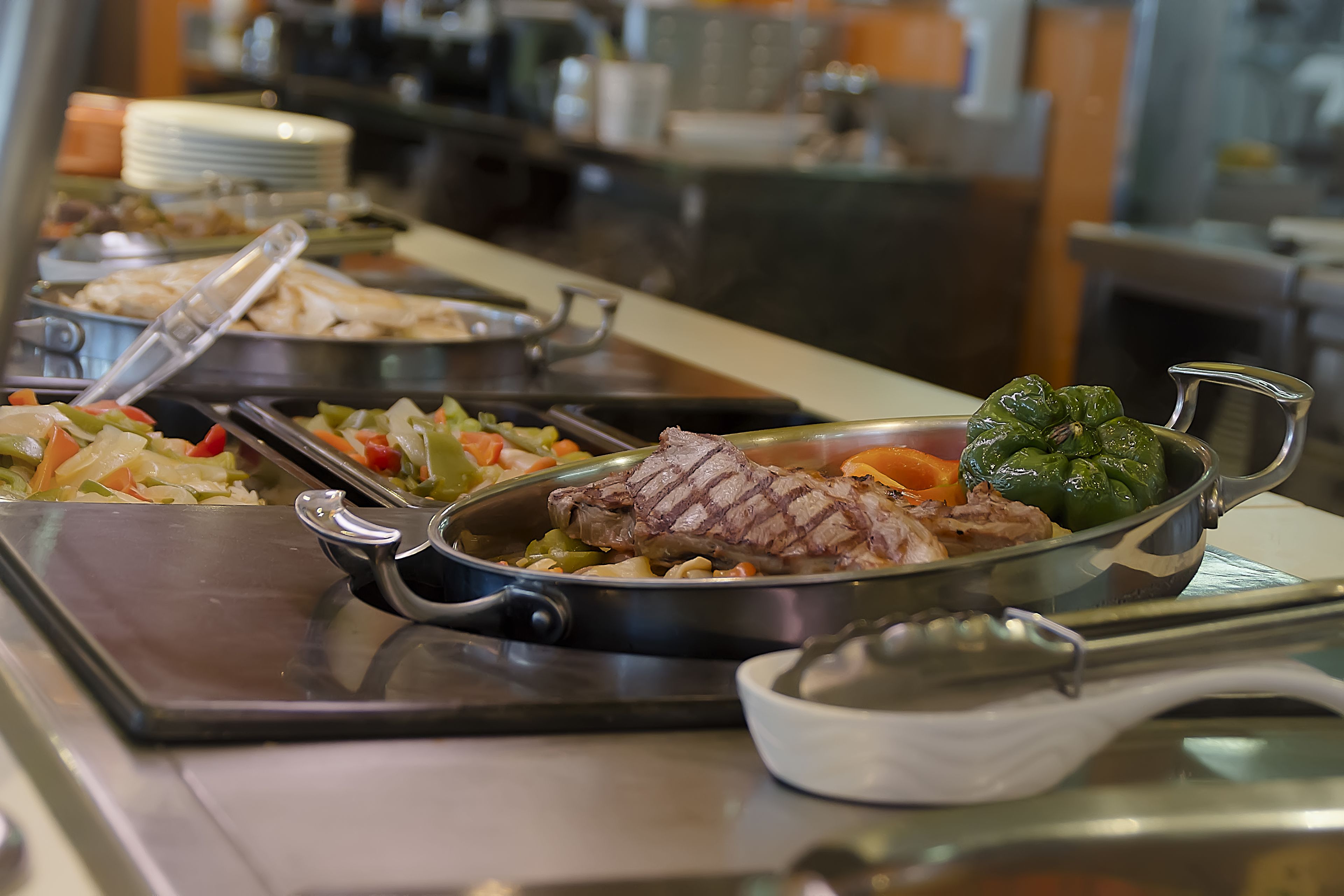 Un buffet proposant une variété de plats, notamment de la viande et des légumes.