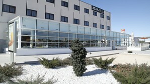 Un hotel moderno con fachada de vidrio, varios pisos y un letrero que dice "AS HOTELS".