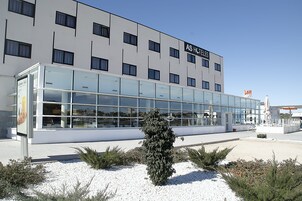 Un hotel moderno con fachada de vidrio, varios pisos y un letrero que dice "AS HOTELS".