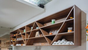 Una cocina con armarios de madera, encimera de granito y techo con diseño.