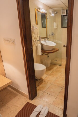 A bathroom with a toilet, sink, and shower. - Ahuja Residency Parklane (Gurugram)