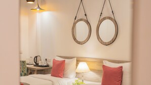 Una habitación de hotel con dos camas, una mesita de noche, una lámpara y un ventilador de techo.