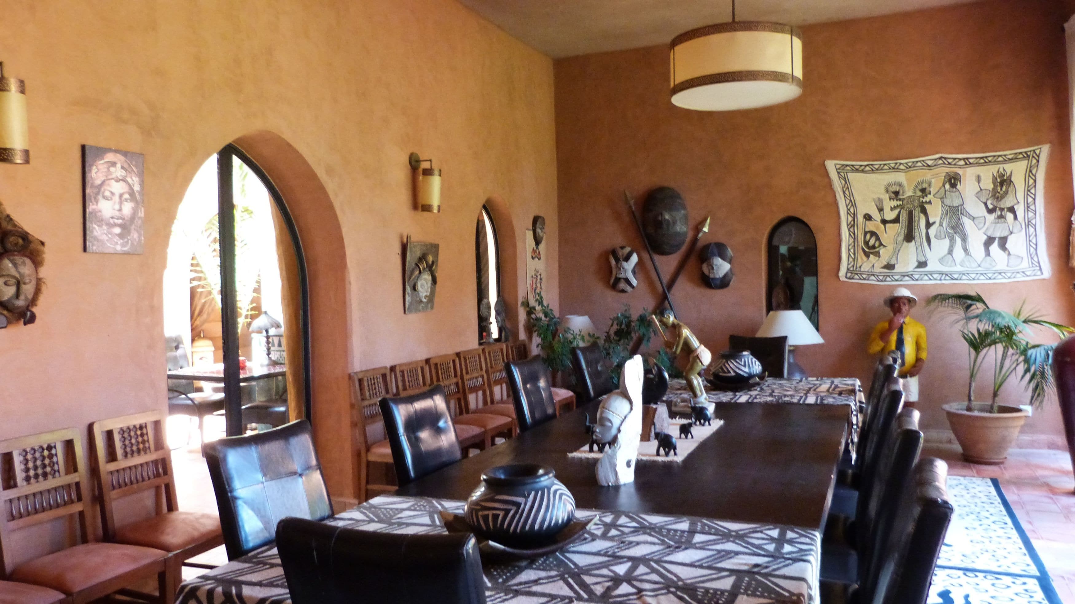 A dining area with a long table, chairs, and various decorative items.