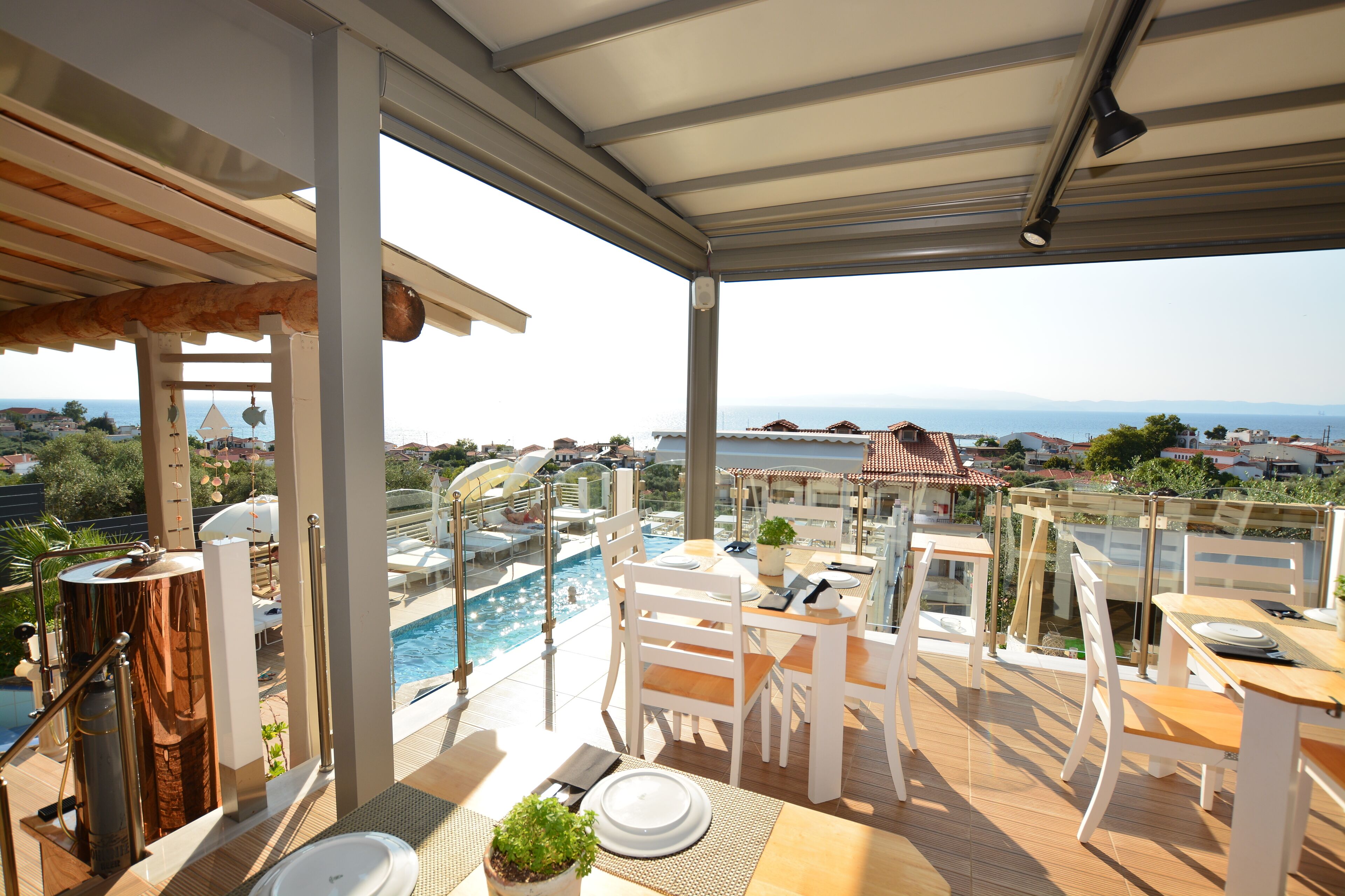 Una terraza en la azotea con piscina, zona de comedor y vistas al mar.